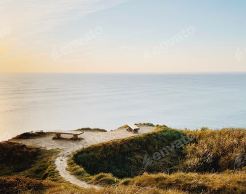 Preview: Atlantic Ocean view from a hill. Peaceful seaside sunset view, benches facing the ocean