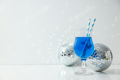 Preview: Blue cocktail with straws in glass and disco balls on white background, space for text
