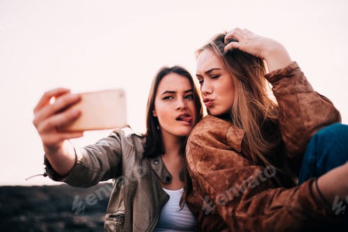 Preview: Teenage Girls pulling faces and taking selfie with smartphone