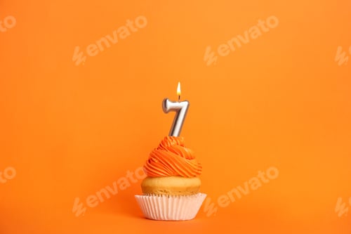 Preview: Birthday cupcake with number seven candle on orange background