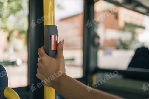 Preview: Woman's hand operating the bus stop request button.