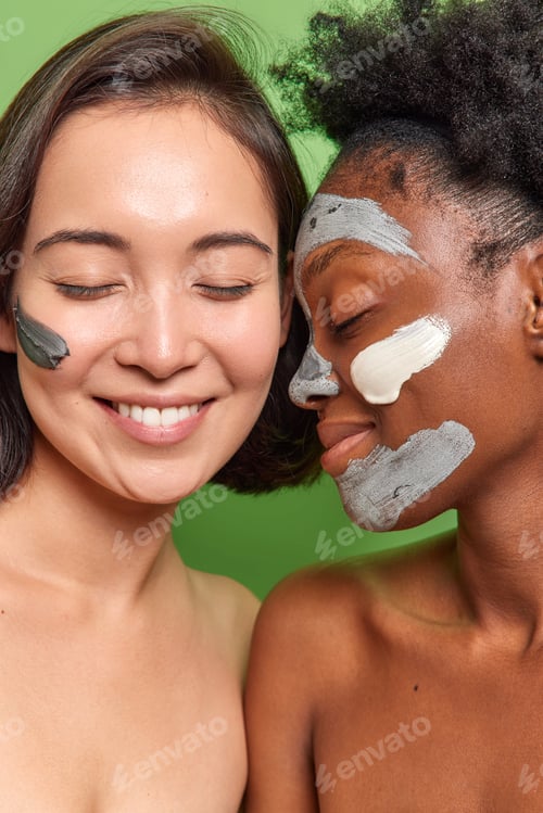 Preview: Headshot of multiethnic women with well cared skin apply nourishing cream and masks smile pleasantly