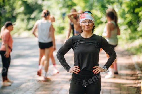 Preview: Against trees with green leaves. Group of runners are together outdoors
