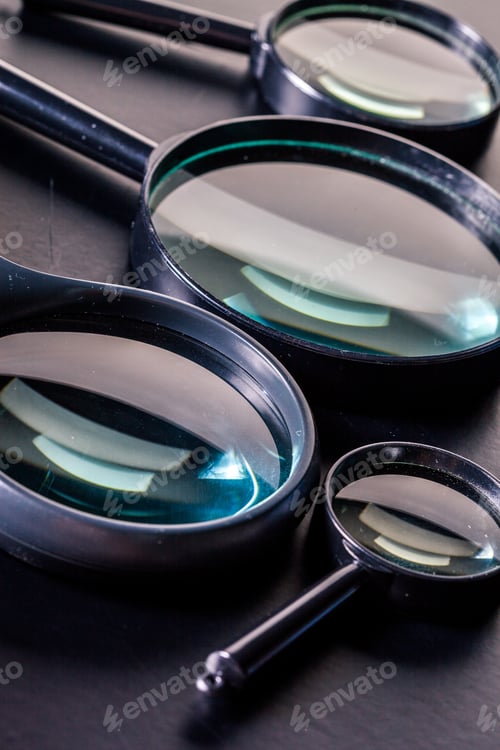 Preview: Closeup of magnifying glass on dark surface