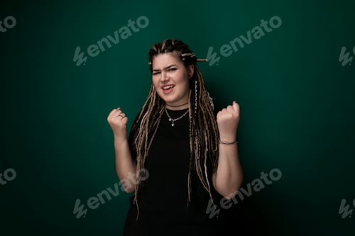 Preview: Woman With Dreadlocks Standing in Front of Green Wall.