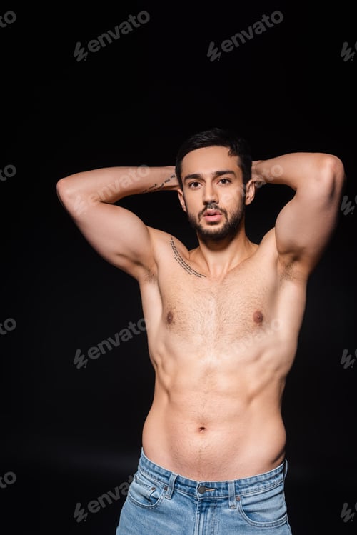 Preview: Muscular man looking at camera isolated on black