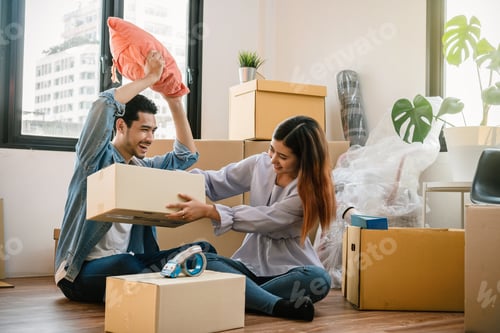 Preview: Asian young couple carrying big cardboard box for moving in new house, Helping relocate