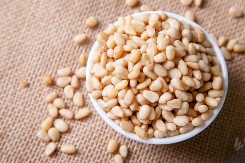 Preview: Organic Pine nuts in a bowl on a jute napkin top view flat lay