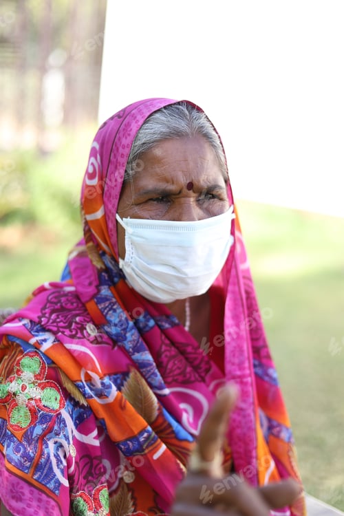 Preview: Vertical portrait of an Indian woman with a traditional dress and white mask