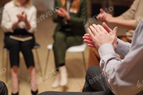Preview: Patients of mental support group clapping hands while sitting in circle during psychological session