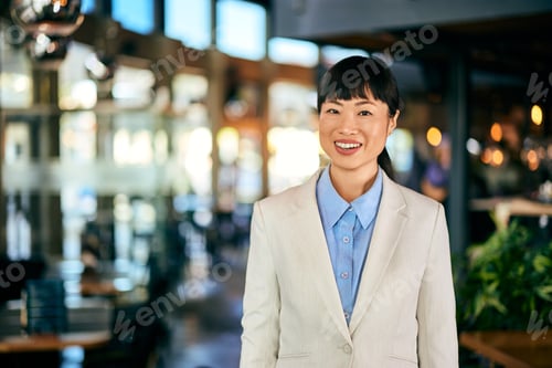 Preview: An elegantly dressed Asian woman, working like a restaurant manager.