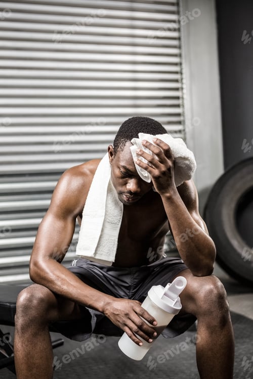 Preview: Shirtless man wiping sweat with towel at the crossfit gym