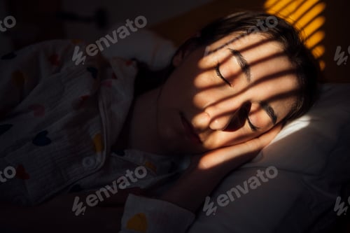 Preview: Close-up portrait of a young woman lying on a pillow and sleeping on a bed