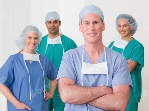 Preview: Confident medical team in scrubs posing with arms crossed in a bright hospital corridor.
