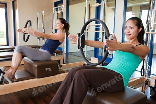 Preview: Two women focused on their pilates workout in a bright studio