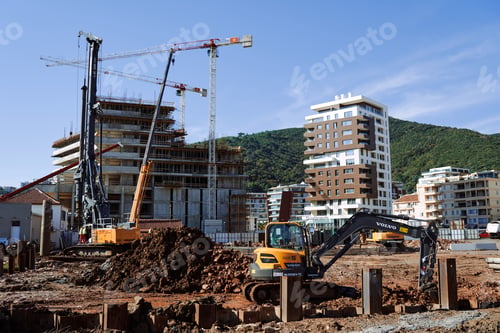 Preview: Drilling machine installs piles at a construction site next to an excavator