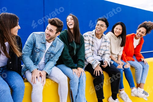 Preview: Young group of happy student friends having fun together sitting outside