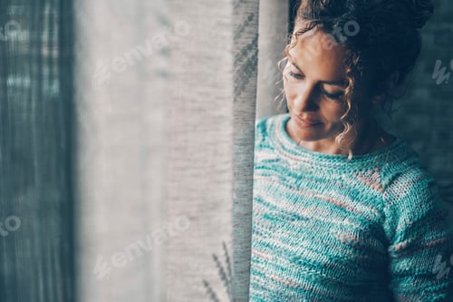 Preview: View of a woman alone at home near the window. Concept of serene people smiling
