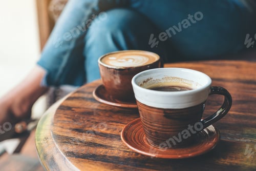 Preview: Closeup image of two cups of hot latte coffee and black coffee on vintage wooden table in cafe