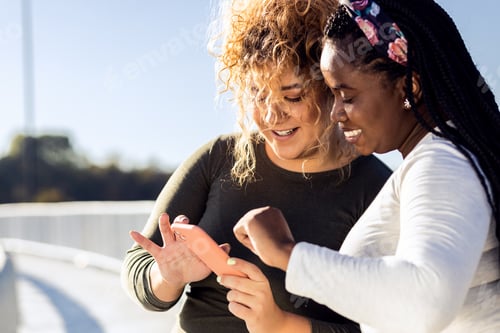 Preview: Two young plus size women resting after running and looking at phone.