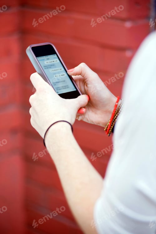 Preview: Close up of young woman's hands texting on smartphone
