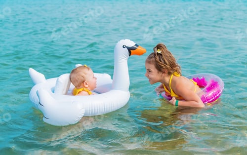 Preview: Sister's children swim in the sea. Selective focus.