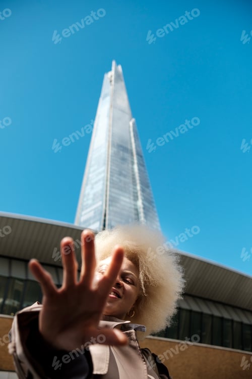 Preview: Albino businesswoman gesturing stop in front of the shard in london