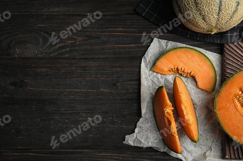 Preview: Flat lay composition with ripe cantaloupe melon on black wooden table. Space for text