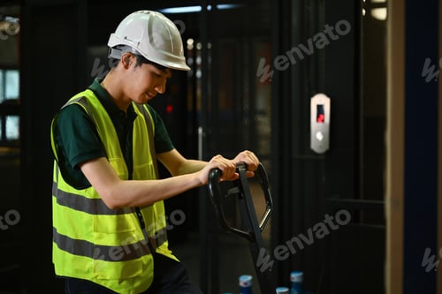 Preview: Warehouse worker pulling pallet truck stack with boxes.