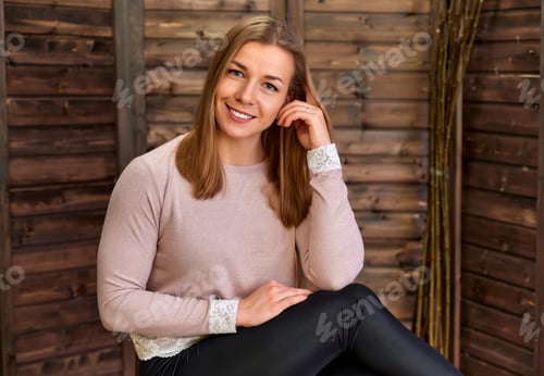 Preview: Loft Style Concept. Portrait Of A Pretty Blonde Girl In A Pink Sweater On A Wooden Background In
