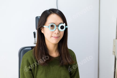 Preview: Woman doing eye test in optical clinic