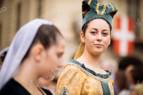 Preview: Young woman in costume with a confident smile participating in a historical parade.