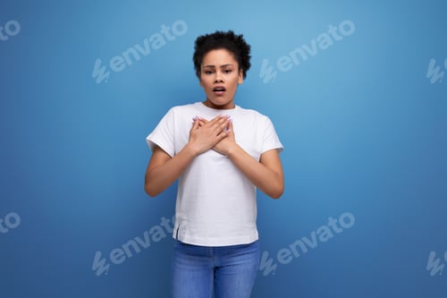 Preview: surprised young brunette woman with afro hair in a white t-shirt opened her mouth