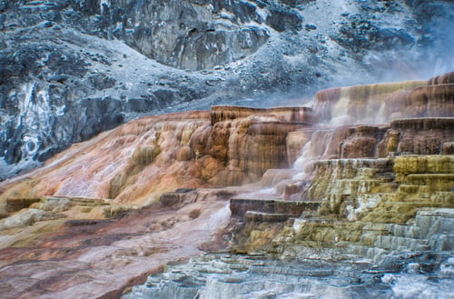 Preview: Beautiful steamy waterfall next to a big mountain on a bright day at the Yellowstone National Park