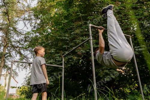 Preview: A man plays on a playground with his son, showcasing their strong bond.