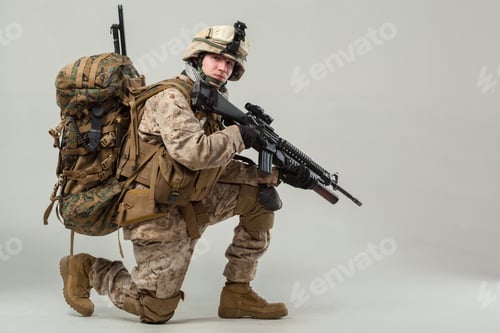 Preview: Soldier in combat gear poses with weapon in a studio setting during training session