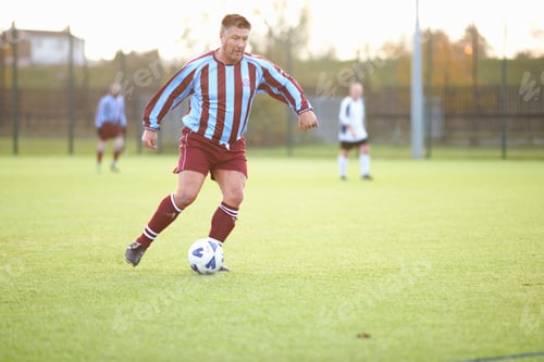 Preview: Football player kicking ball