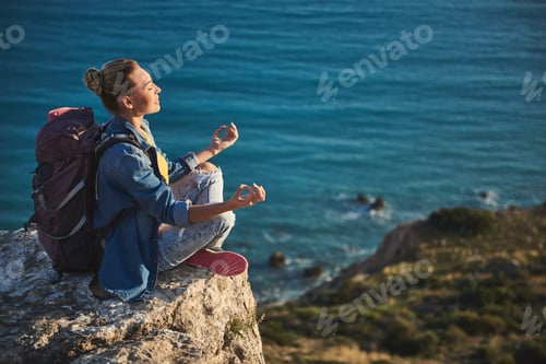 Preview: Profile Of Quiet Girl Taking Her Seat In Lotus Pose On High. Her Eyes Are Closed. Coastline On