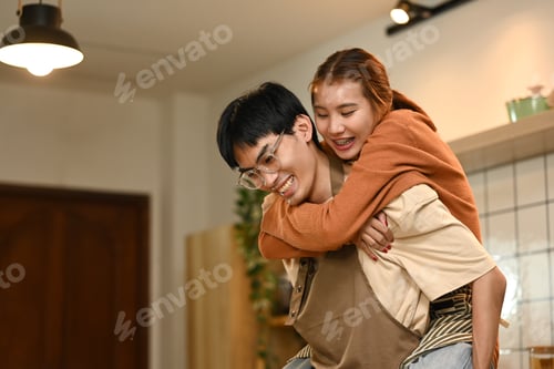 Preview: Playful young couple preparing meal and sharing a romantic moment in kitchen