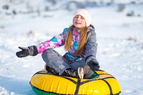 Preview: Girl Sits on Snow Tube in Snowy Landscape
