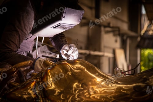 Preview: Man in mask welding metal ware in darkness