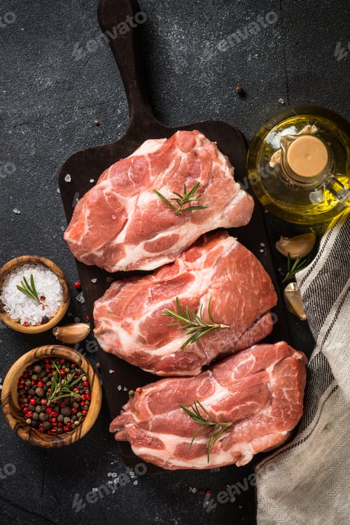 Preview: Fresh steaks with herbs and spices at black background.