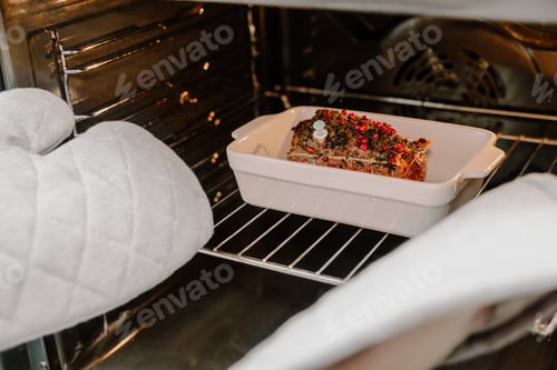 Preview: Hands in potholders take roast beef from the oven. Festive Christmas dinner.