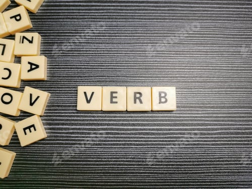 Preview: Word verb made from square letter tiles against black background.