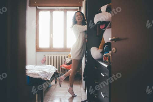 Preview: Young woman searching closet at home
