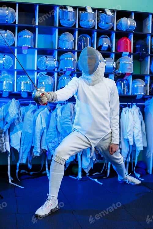 Preview: Young guy in a fencing suit with a sword in his hand, on a blue background, neon light