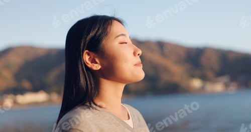 Preview: Japanese woman, breathing and peace outdoor, lake or ocean with travel, holiday and mindfulness in