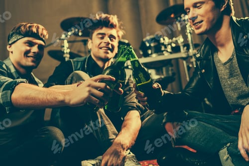 Preview: selective focus of cheerful friends clinking glass bottles of beer