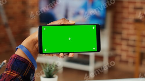 Preview: Young adult holding telephone with horizontal greenscreen