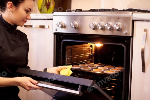 Preview: Woman Baking Cupcakes in Bright Kitchen